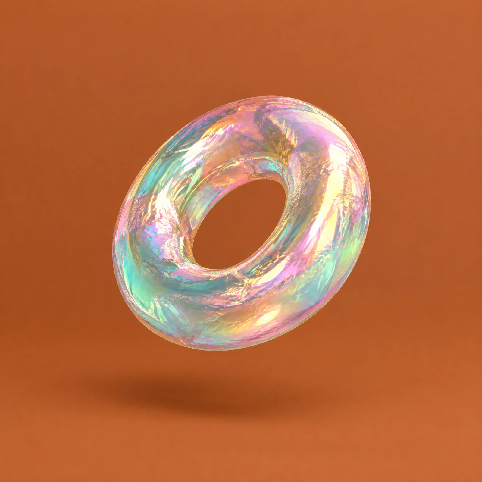 Iridescent holographic foil torus ring floating at an angle over a terracotta orange background